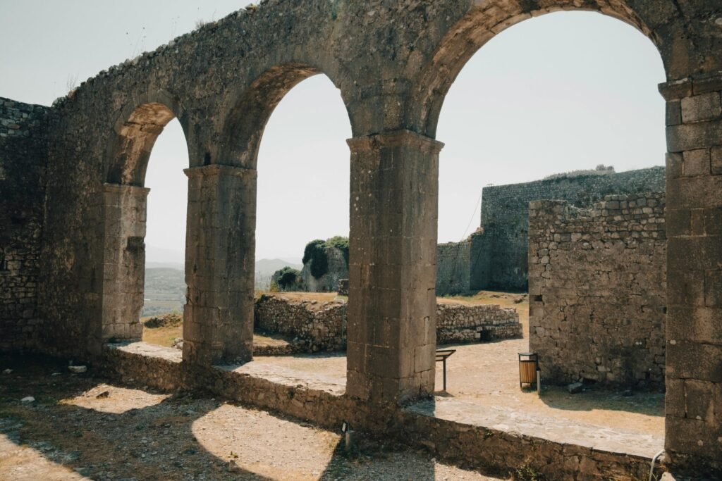 Explore the ancient stone arches of Rozafa Castle in Shkodër, Albania, bathed in warm summer light.